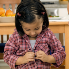Enfant qui attache des boutons