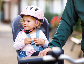 Fillette assise dans un siège de vélo