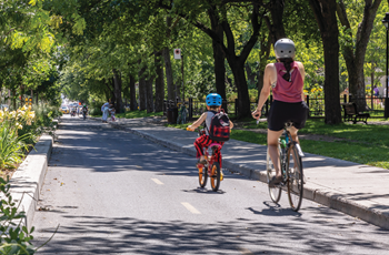 Une mère et son garçon pédalent sur leur vélo l’un derrière l’autre