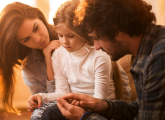 Des parents réconfortent leur enfant à la suite de la mort d’un être cher.