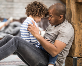 Un père réconforte son enfant qui vit un deuil.
