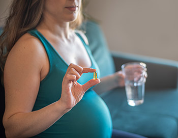 Pregnant woman taking prenatal multivitamins