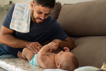 Papa immigrant change la couche de son bébé