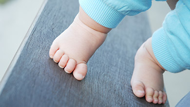 Bébé marche sur la pointe des pieds, de travers